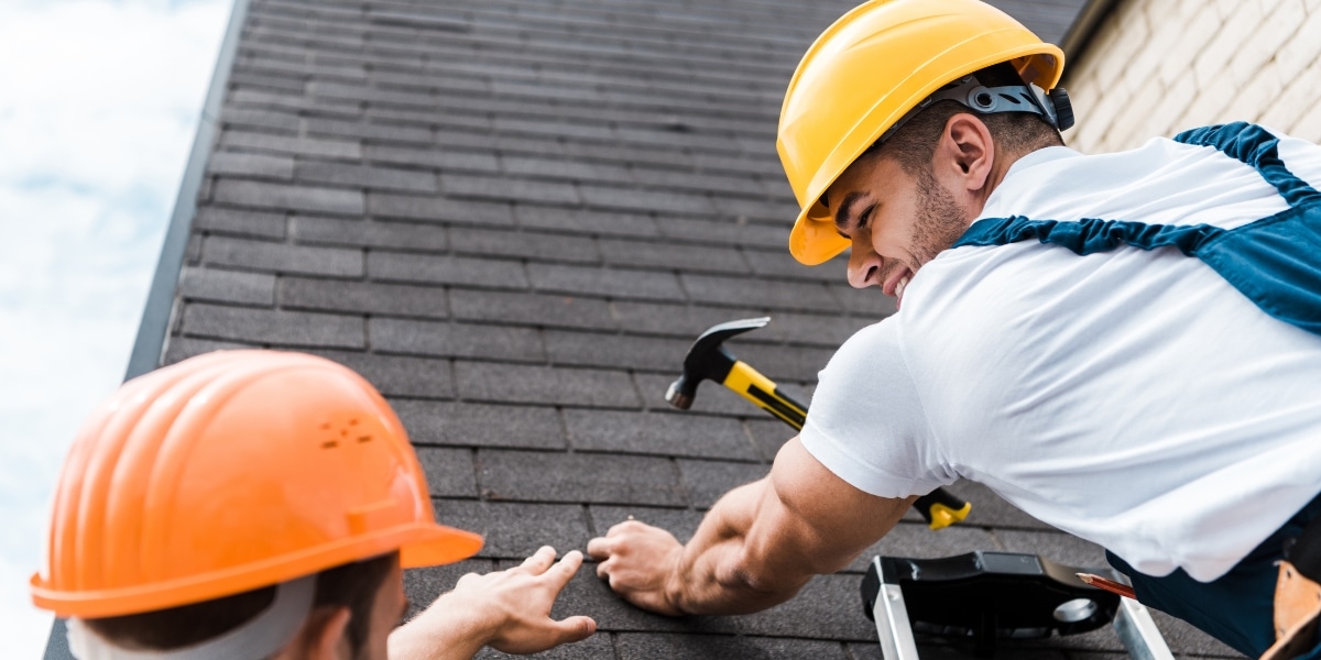 Roofing contractors installing impact-resistant shingles, demonstrating professional craftsmanship and durable materials for storm protection.