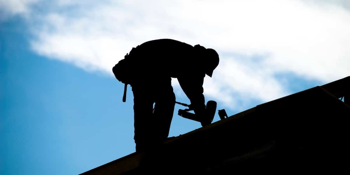 Roofers dressed in winter gear working on a roof, ensuring quality installation during the cooler months in Louisiana and Mississippi